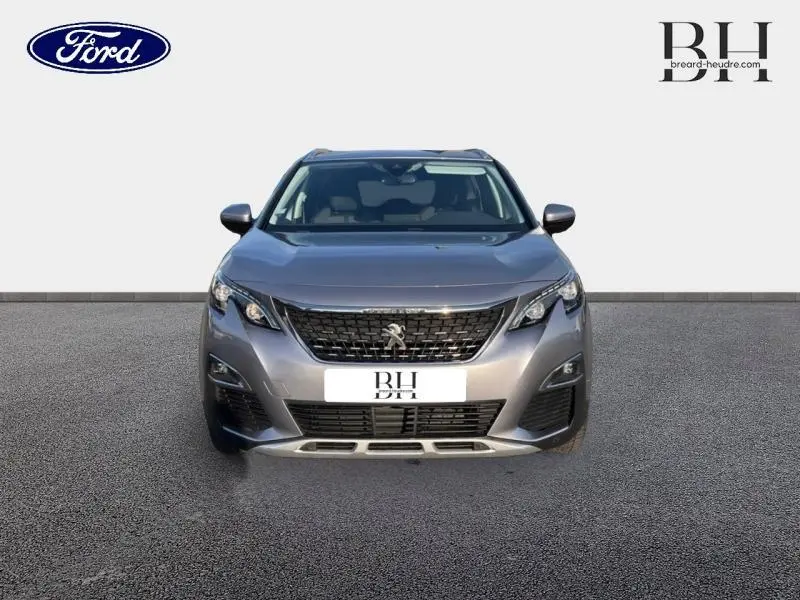 Vue de face du Peugeot 5008 gris Artense avec calandre noire et phares LED distinctifs.