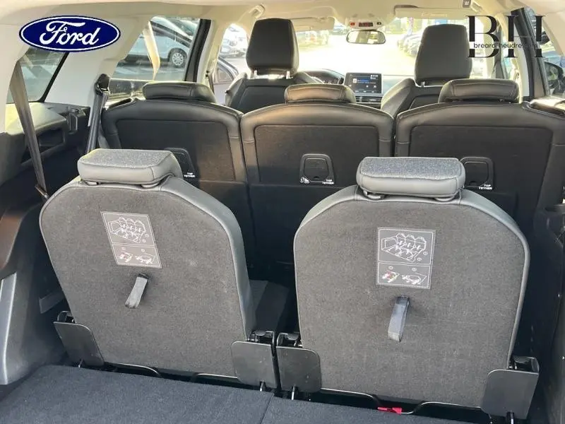 Vue arrière intérieure du Peugeot 5008 gris Artense, montrant les sièges arrière relevés et la troisième rangée.