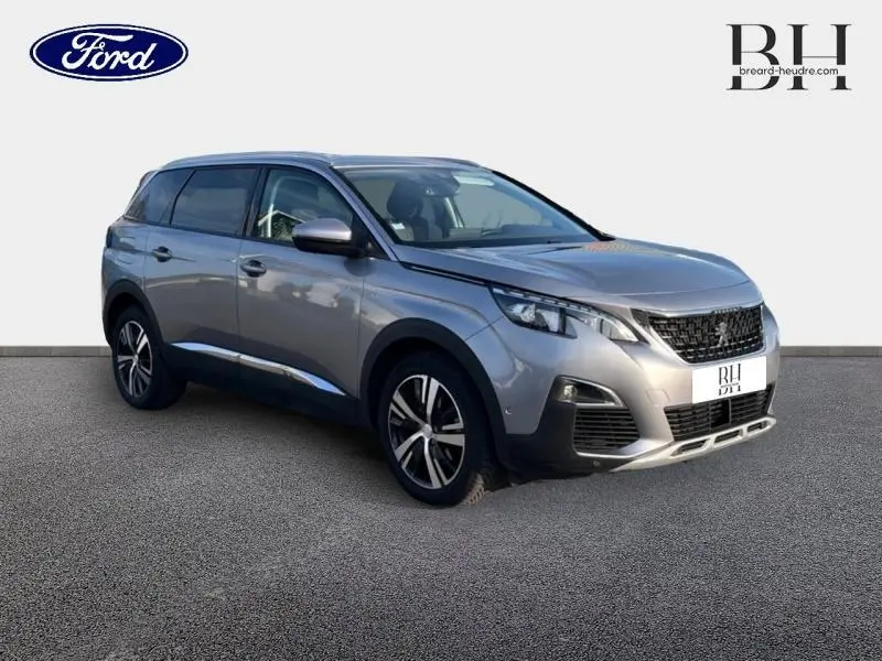 Peugeot 5008 gris Artense vue 3/4 avant droit, mettant en valeur ses jantes alu et son design moderne.