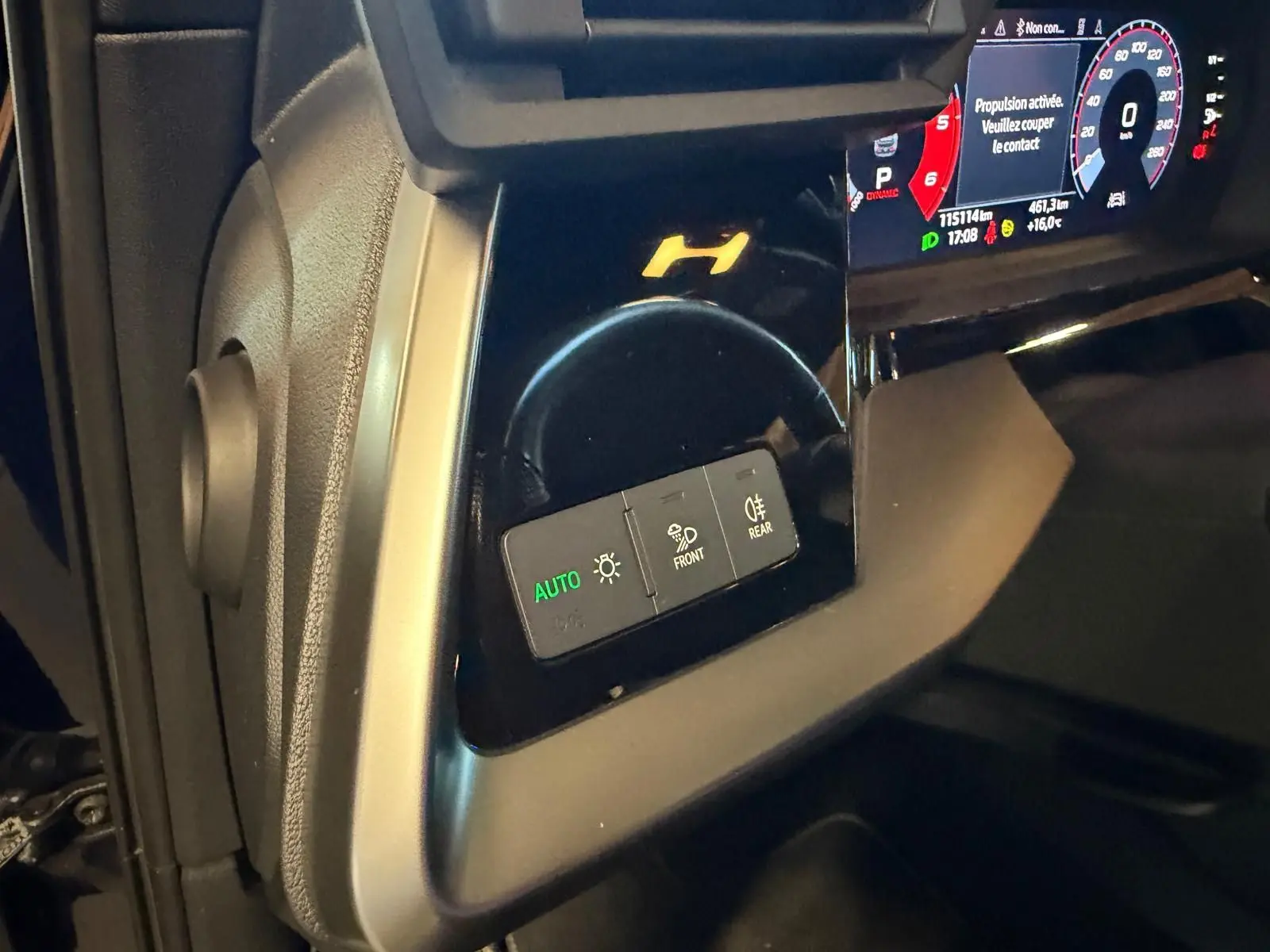 Détail du tableau de bord côté gauche d’une Audi A3 bleu 2022, avec commandes d’éclairage et affichage numérique.