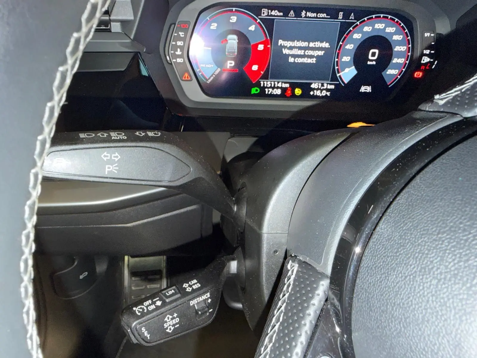 Vue rapprochée du tableau de bord et du volant noir perforé d’une Audi A3 2.0 TDI 150 S-TRONIC S-LINE avec affichage numérique coloré.