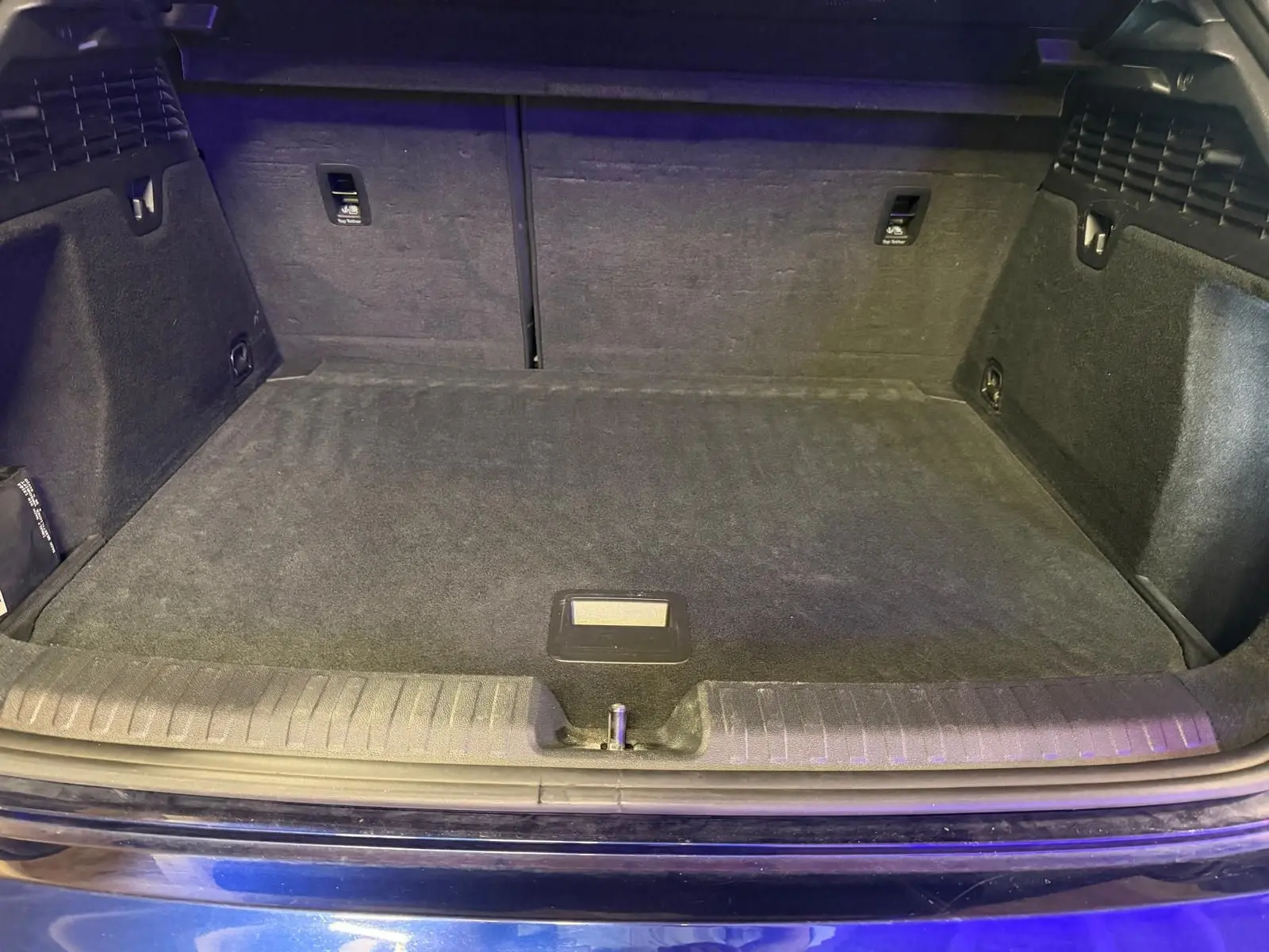 Coffre ouvert vu de face d’une Audi A3 bleu 2022, montrant un espace de chargement propre et spacieux.