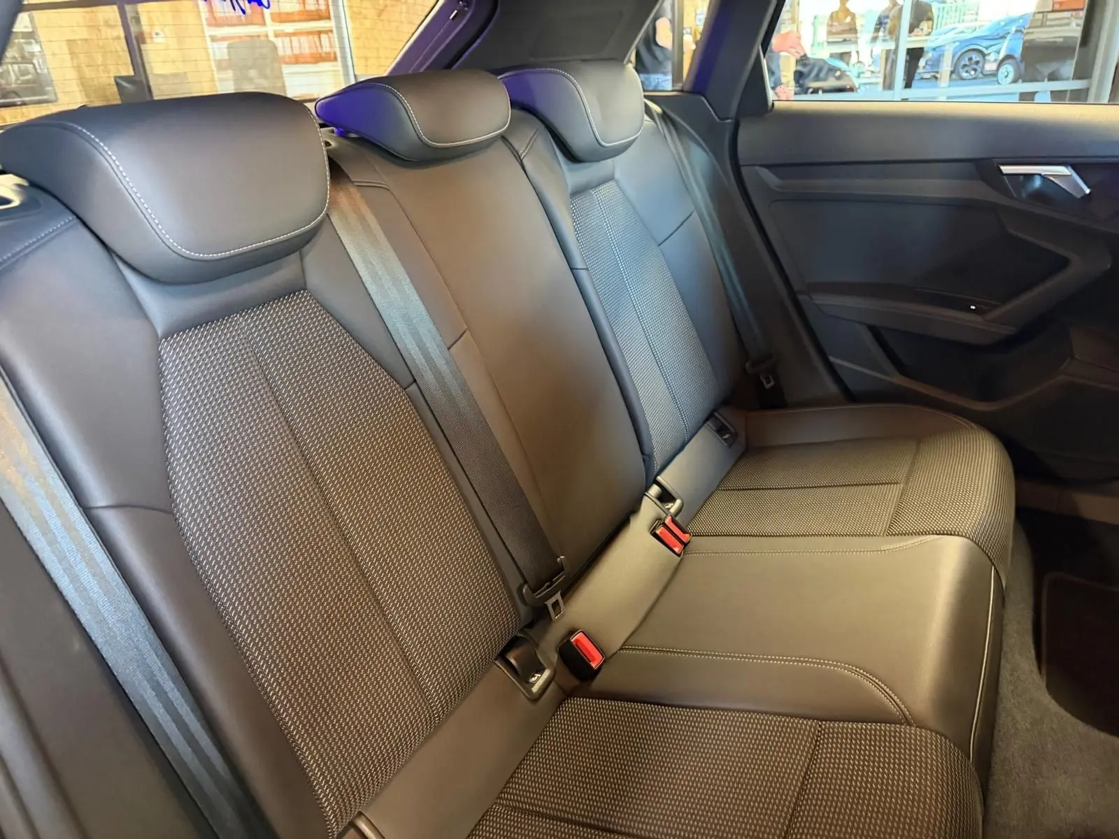Vue intérieure de la banquette arrière en tissu noir de l'Audi A3 2.0 TDI S-Line, avec ceintures et appuie-têtes visibles.