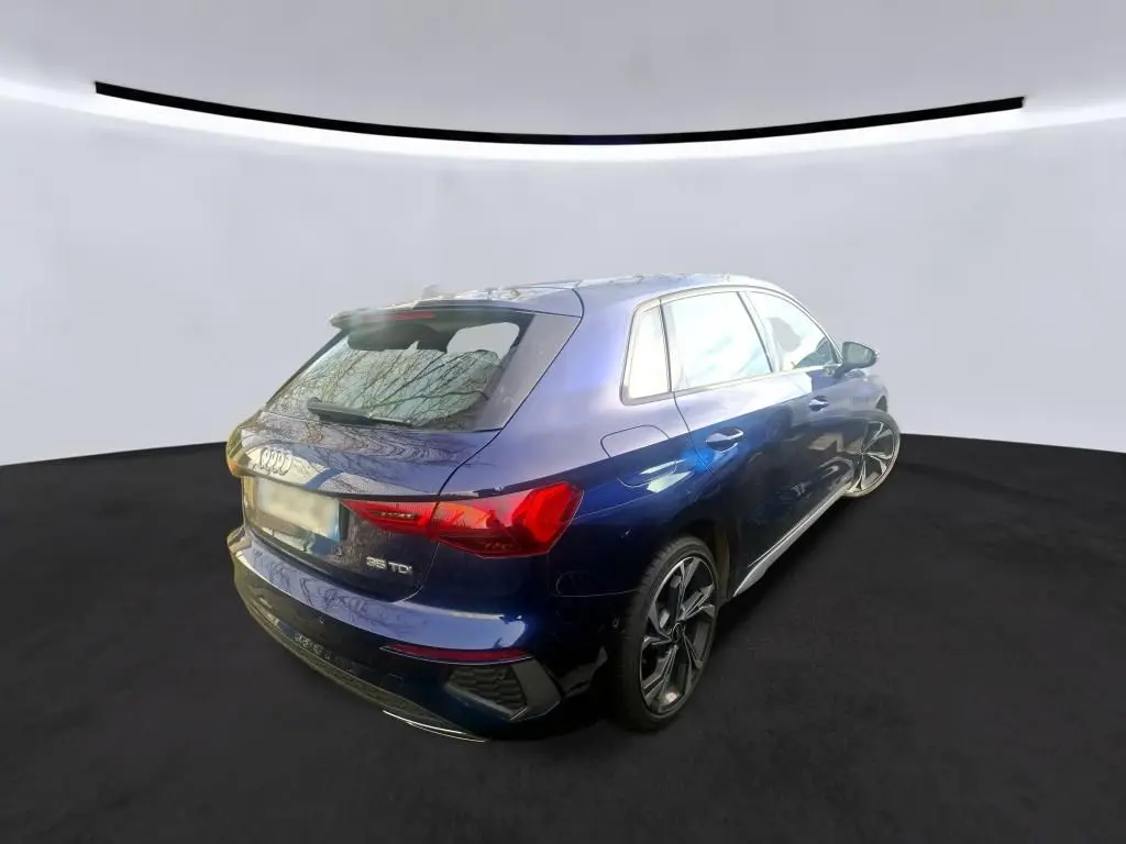 Audi A3 2.0 TDI S-Line bleu vue de profil côté gauche, avec jantes alliage distinctives en intérieur bois.