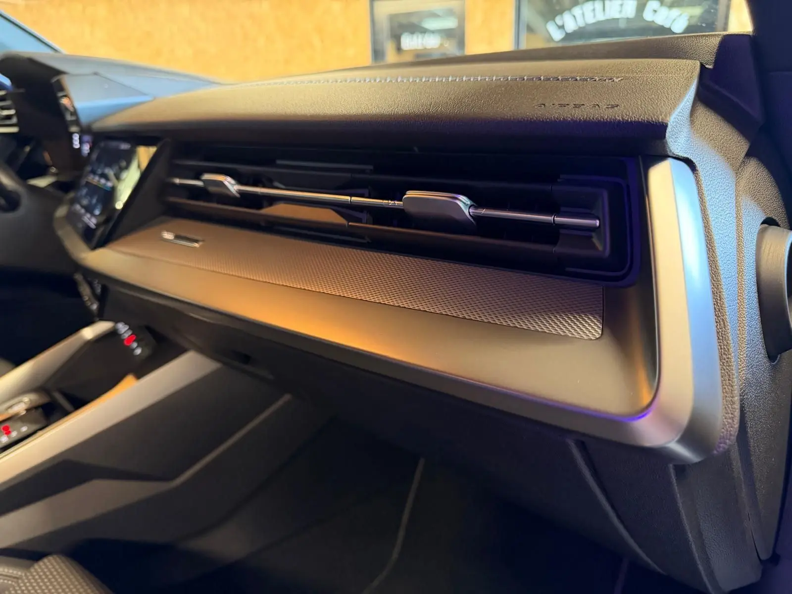 Vue intérieure de l'Audi A3 2.0 TDI 150 S-TRONIC S-LINE 2022, tableau de bord noir avec aérateurs horizontaux et finition métal.