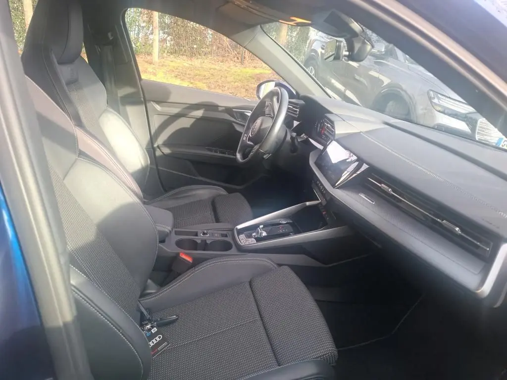 Gros plan sur la roue avant droite bleu foncé d’une Audi A3 2.0 TDI S-Line avec jante alliage à design géométrique.