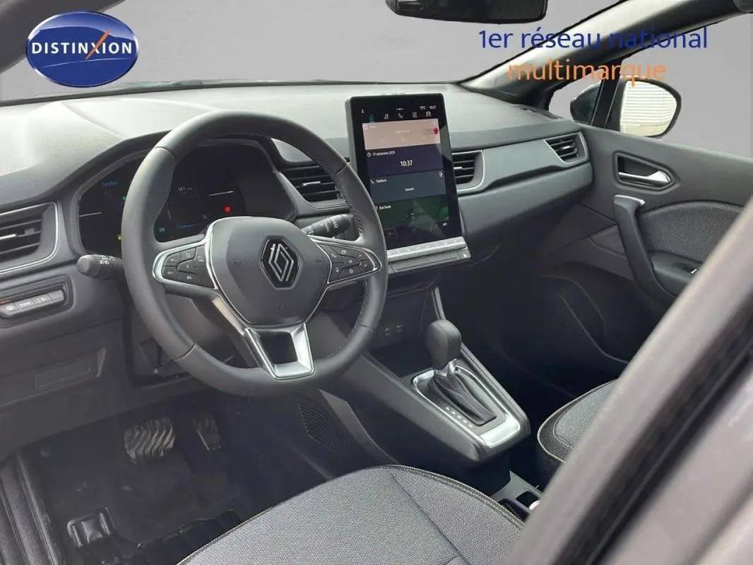 Vue intérieure côté conducteur du Renault Captur gris 2025, avec volant cuir et écran tactile vertical central.