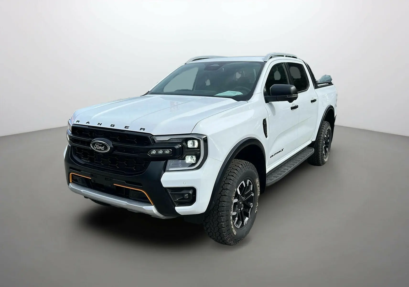 Ford Ranger 2025 blanc glacier en 3/4 avant droit avec calandre noire et détails orange sur pare-chocs.