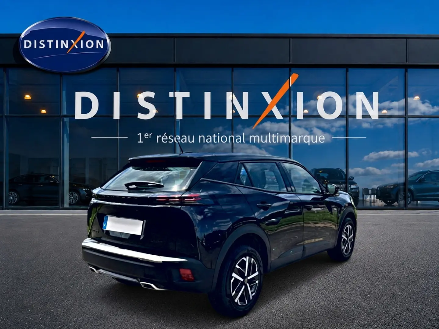 Peugeot 2008 noir vue 3/4 arrière droit, avec feux arrière LED et jantes alliage, devant vitrine Distinxion.