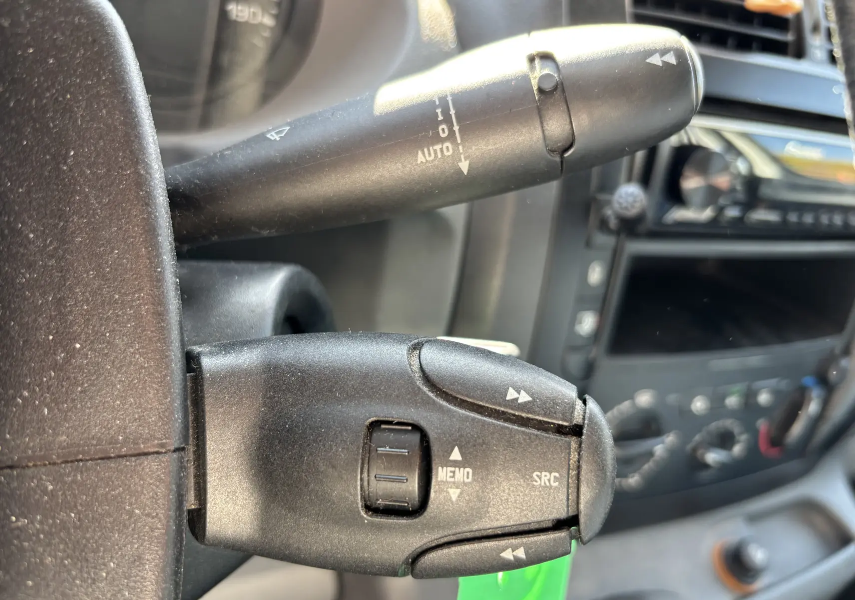 Gros plan sur les commandes au volant du FIAT Scudo Fourgon blanc, avec tableau de bord et console en arrière-plan.