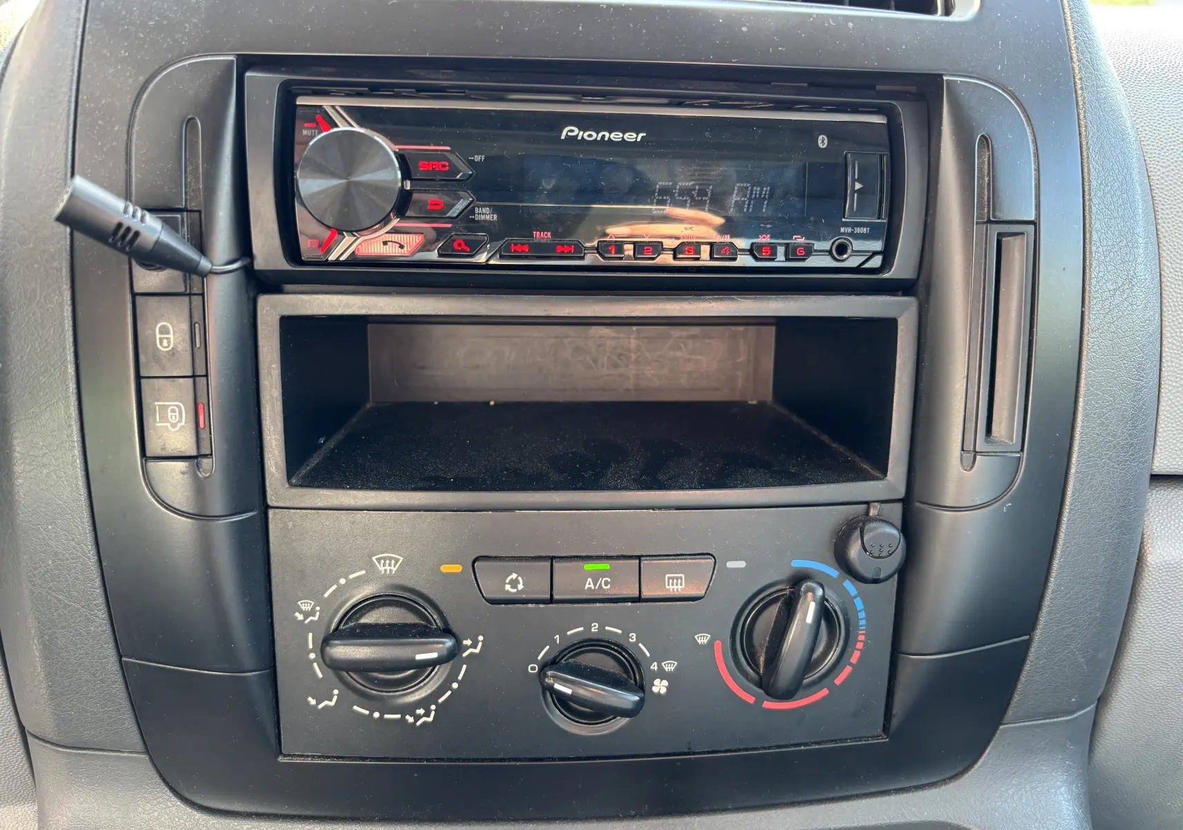 Vue rapprochée de la console centrale noire du Fiat Scudo Fourgon blanc, avec radio Pioneer et commandes de climatisation.