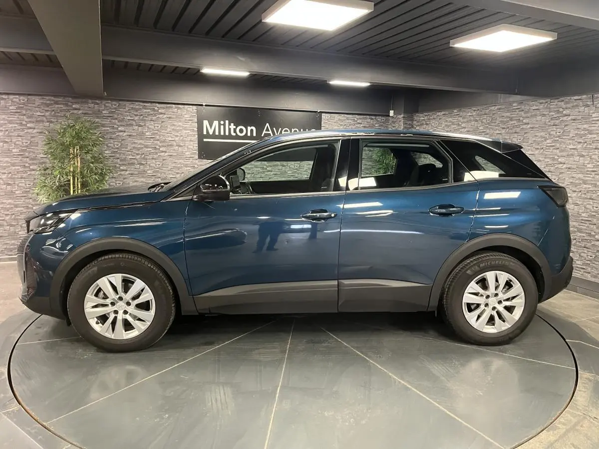 Profil côté gauche du Peugeot 3008 bleu métallisé 2022 avec jantes alliage et coques de rétroviseurs noires.