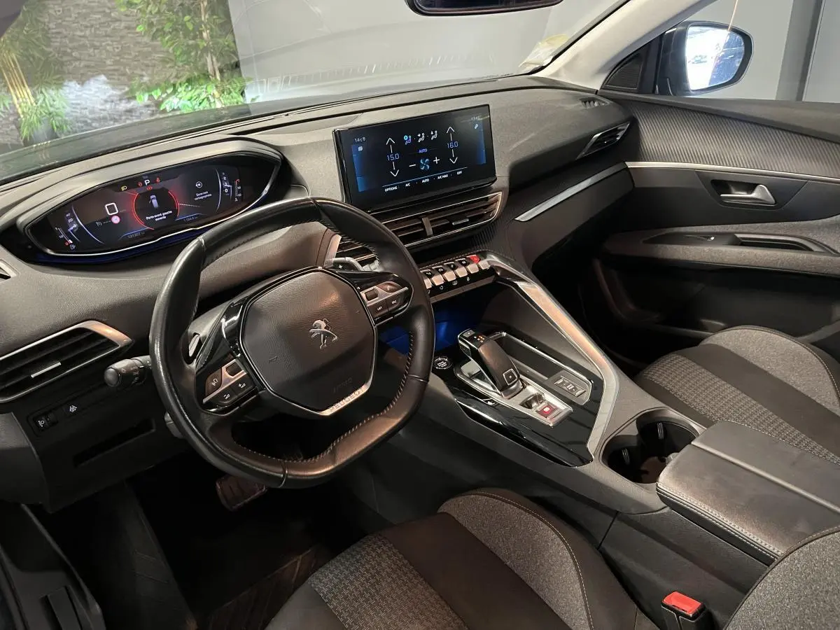 Intérieur du Peugeot 3008 2022 vu côté conducteur, volant compact cuir et écran tactile central lumineux.