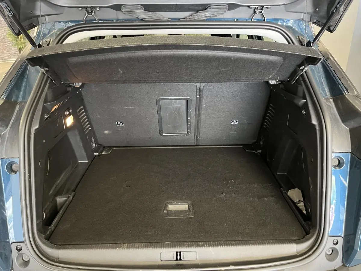 Coffre ouvert du Peugeot 3008 bleu, vue arrière montrant l'espace de chargement et la trappe de passage skis.