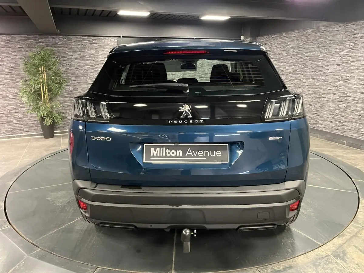 Vue arrière d'un Peugeot 3008 bleu avec attelage démontable et feux arrière LED distinctifs dans un showroom.