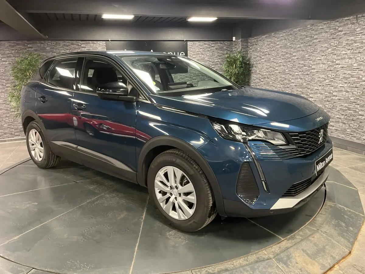 Peugeot 3008 bleu 3/4 avant droit en intérieur, avec calandre noire et jantes alliage 17 pouces.