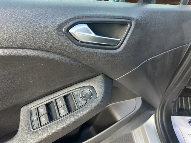 Détail de la porte avant gauche de la Renault Clio V TCE 90 Evolution 2023 avec commandes électriques et poignée argentée.