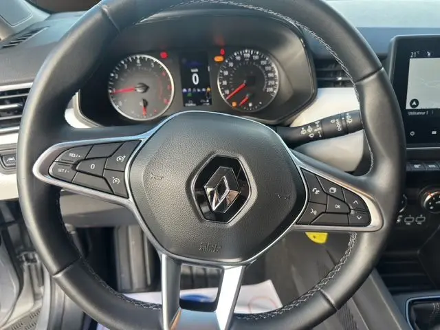 Vue rapprochée du volant multifonction en cuir noir et du tableau de bord numérique de la Renault Clio V gris Highland 2023.