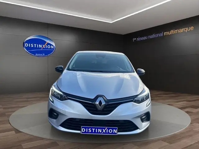 Vue avant d'une Renault Clio V gris Highland avec projecteurs Full LED et calandre noire dans un showroom.