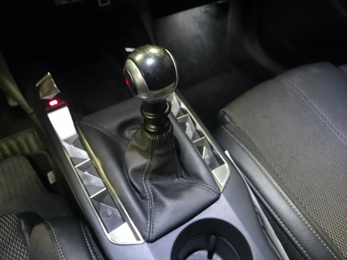 Gros plan sur le levier de vitesses manuel en cuir noir et tissu gris du DS3 Crossback 1.5 BlueHDi Bastille 2022.