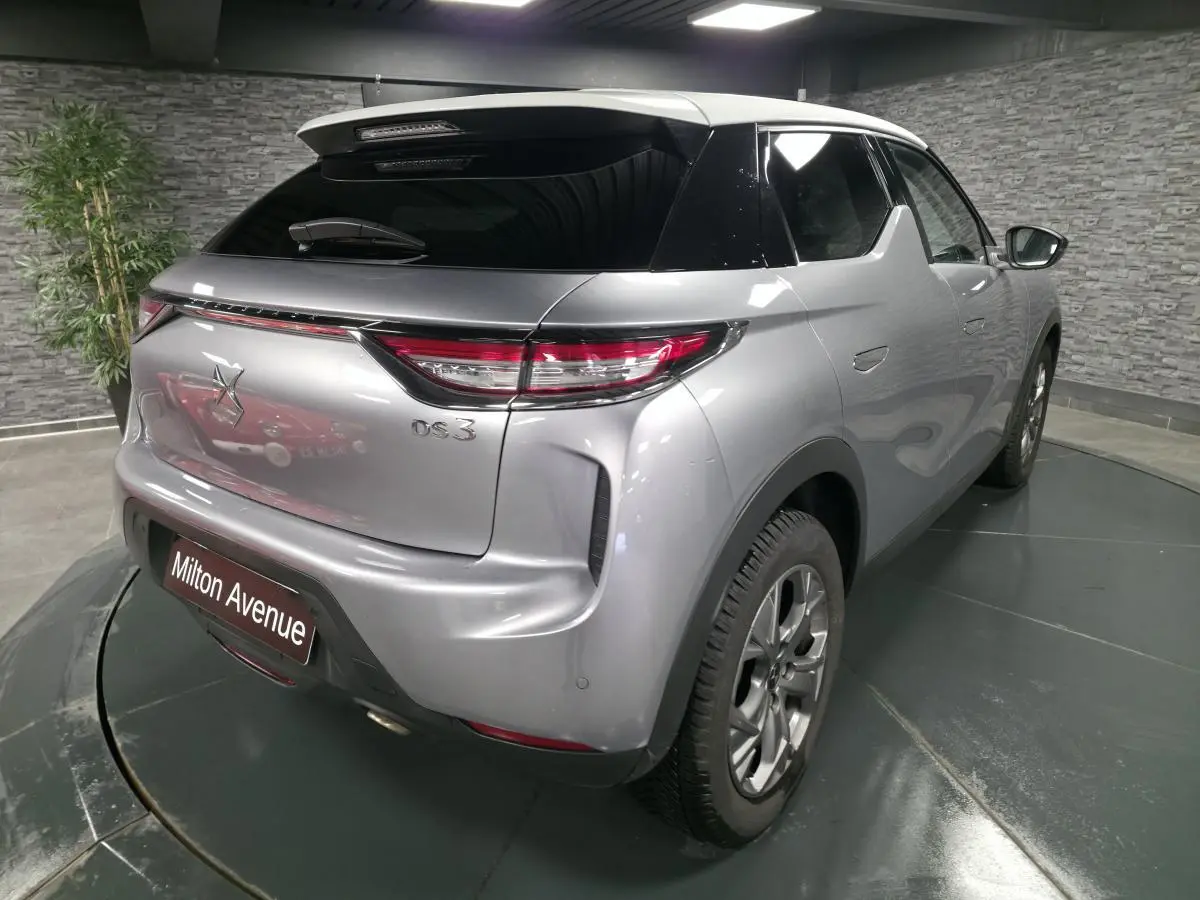 Vue 3/4 arrière droite d'un DS3 Crossback gris métallisé avec toit noir et feux arrière LED distinctifs.