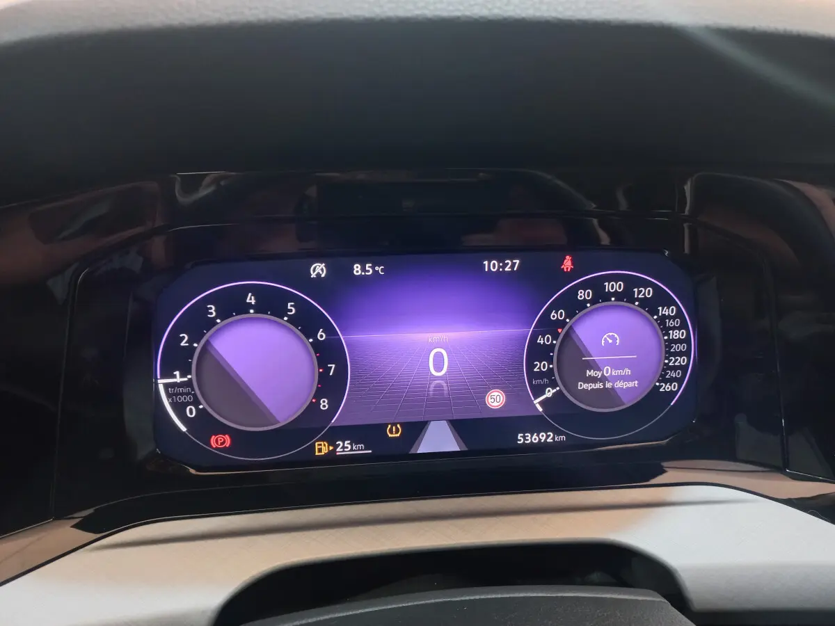 Affichage numérique du tableau de bord de la Volkswagen Golf 2022, avec compte-tours et vitesse à zéro, fond violet.