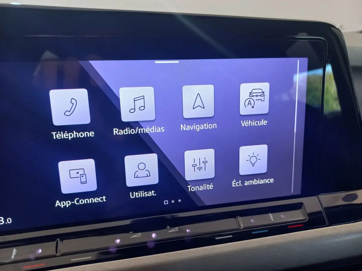 Écran tactile central de la Volkswagen Golf 1.5 bleu affichant les menus téléphone, navigation et ambiance lumineuse.