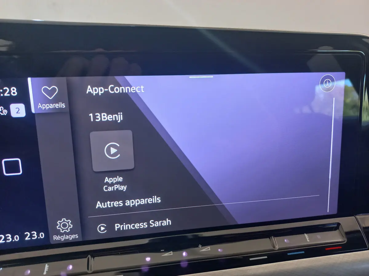 Écran tactile central de la Volkswagen Golf bleue 2022 affichant Apple CarPlay et options connectées.