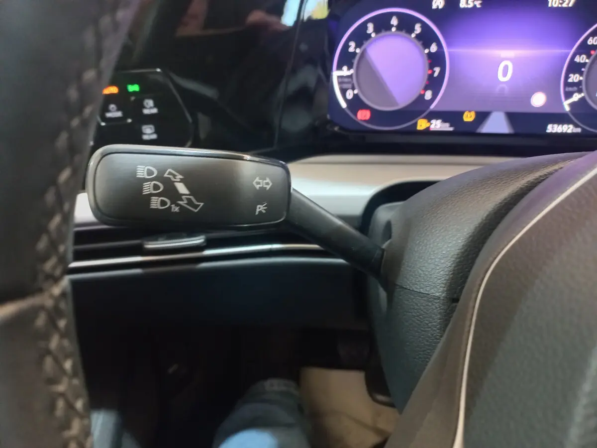 Gros plan sur la manette de clignotants à gauche du volant dans le tableau de bord numérique d'une Volkswagen Golf bleue 2022.