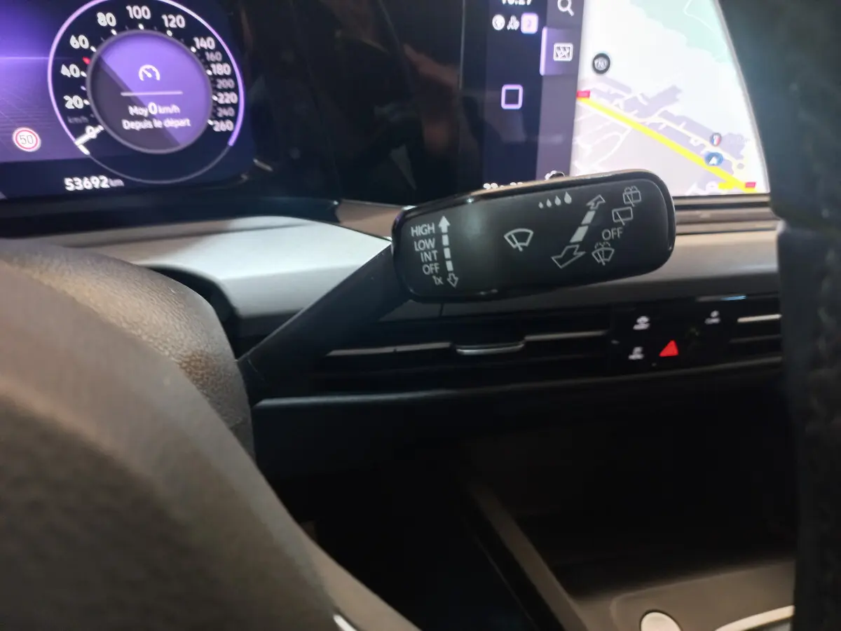 Gros plan sur la commande d’essuie-glace à gauche du volant dans le tableau de bord numérique de la Volkswagen Golf bleue 2022.