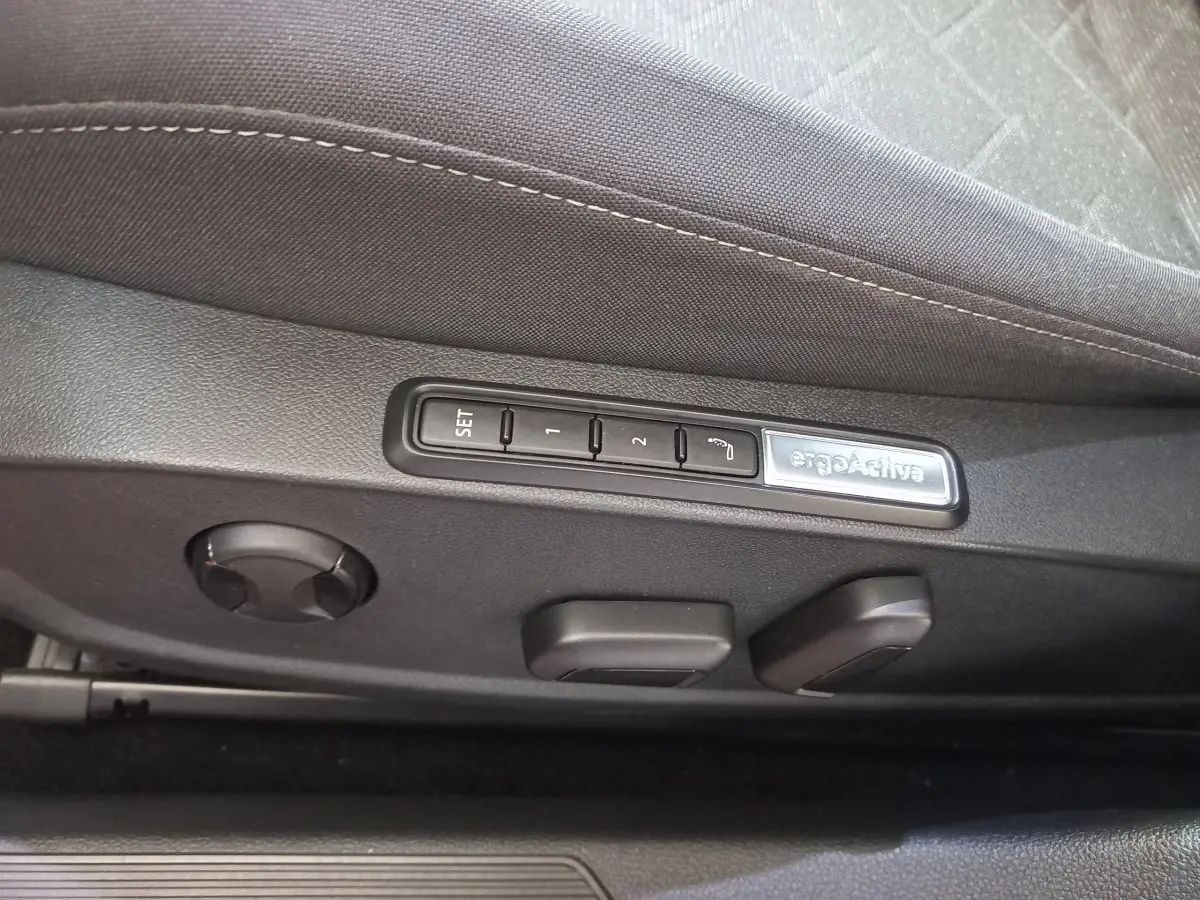 Détail des commandes de réglage de siège noir avec mémoire ergonomique ergoActive dans une Volkswagen Golf 2022.