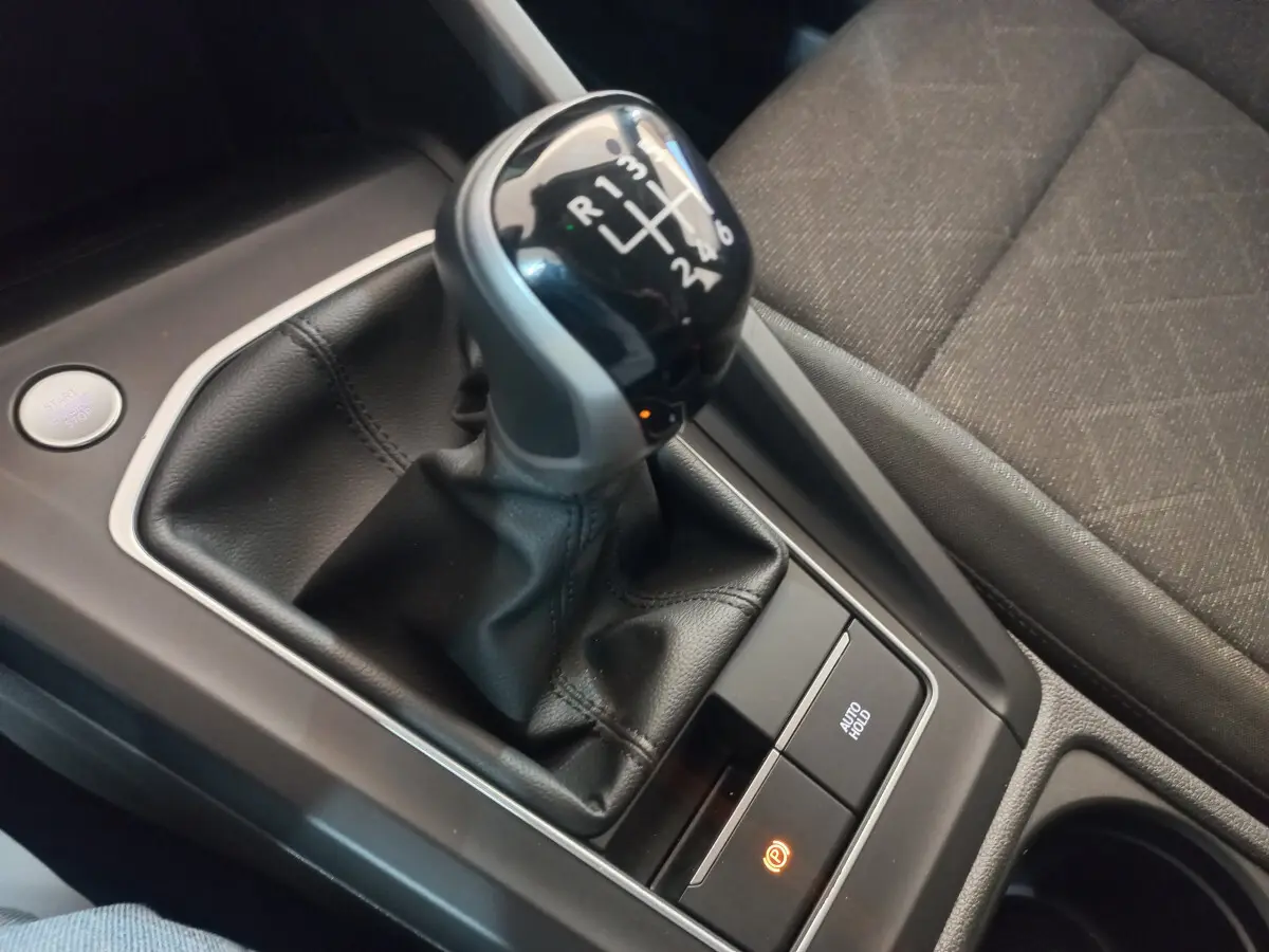 Gros plan sur levier de vitesse manuel noir et console centrale avec bouton démarrage dans Volkswagen Golf bleu 2022