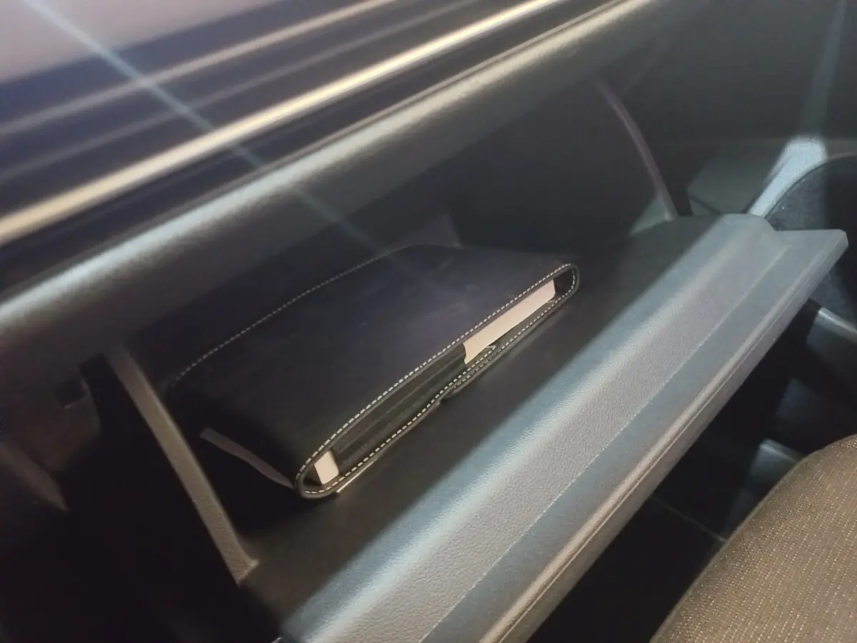 Gant de boîte à gants ouvert avec un carnet noir à l'intérieur, intérieur sombre de Volkswagen Golf 2022.