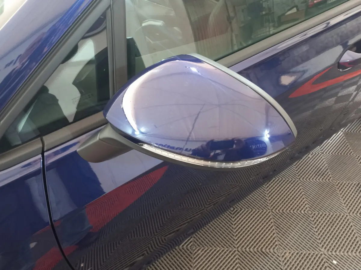 Rétroviseur côté gauche bleu de la Volkswagen Golf 1.5 ETSI 2022 avec clignotant intégré, vue rapprochée.