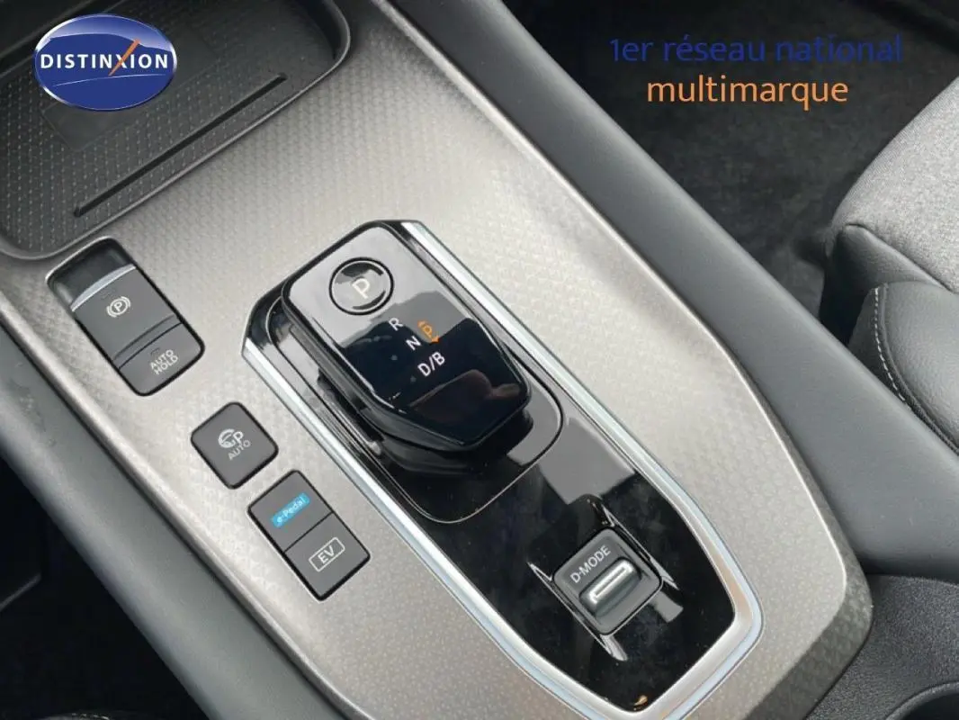 Gros plan sur la console centrale du Nissan Qashqai gris 2025, avec levier de vitesses automatique et boutons de contrôle.