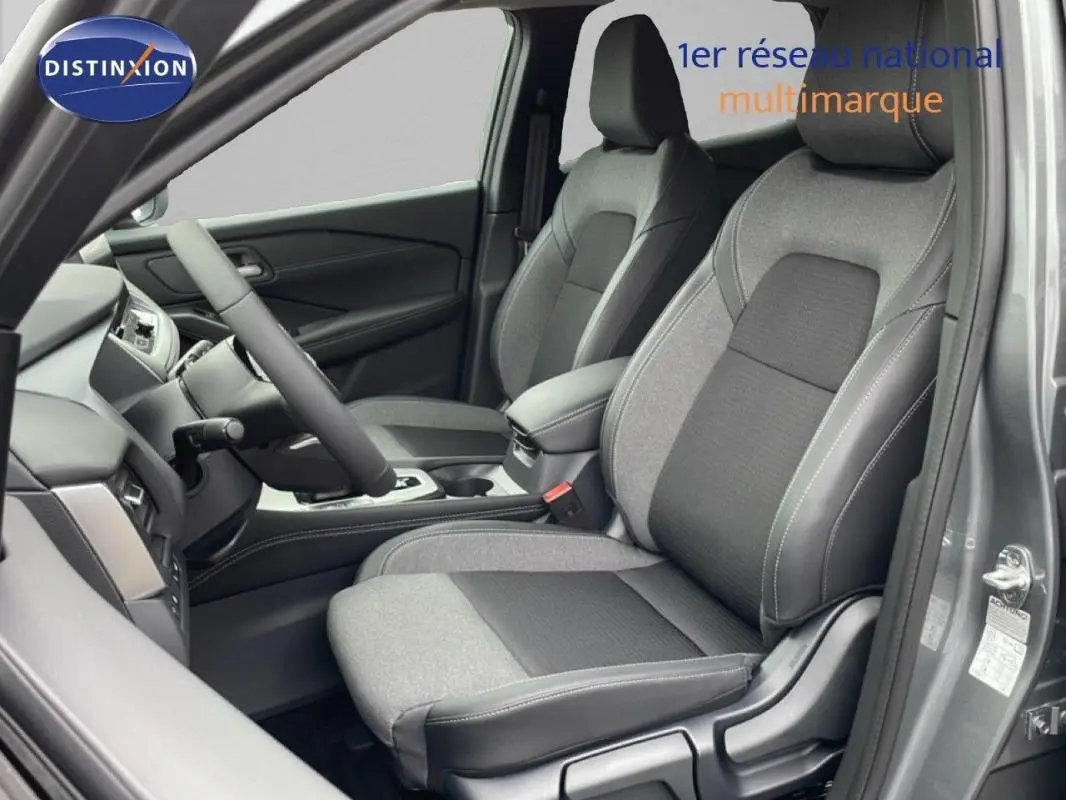 Vue intérieure côté conducteur du Nissan Qashqai gris 2025, mettant en valeur les sièges bi-matière et le volant multifonctions cuir.