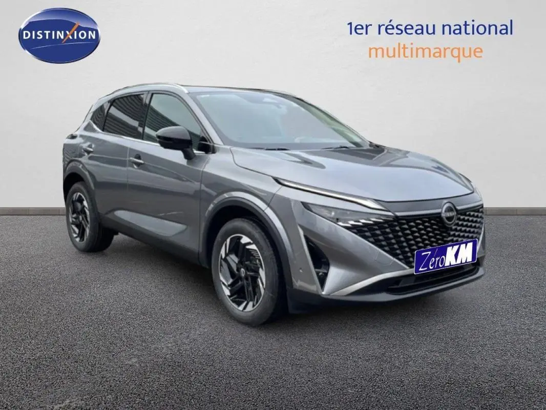 Vue 3/4 avant d’un Nissan Qashqai gris 2025 avec calandre noire et jantes aluminium distinctives.