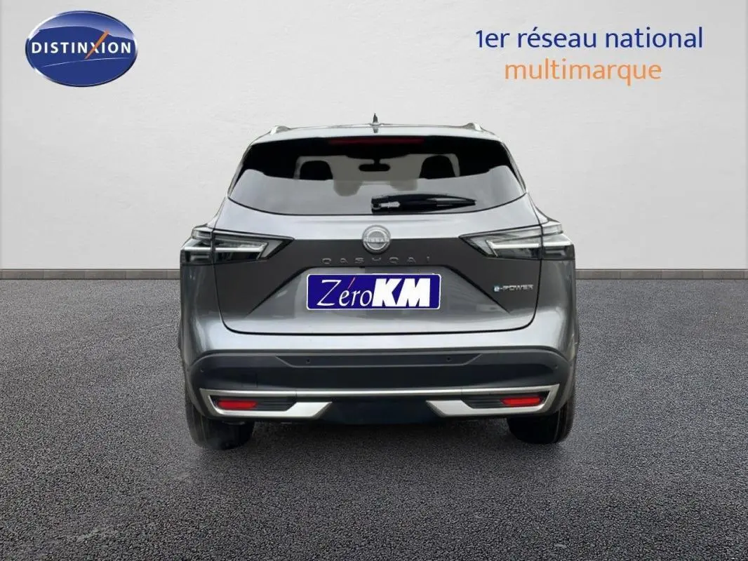 Vue arrière d'un Nissan Qashqai gris 2025 avec barres de toit et logo e-POWER visible sur le hayon.