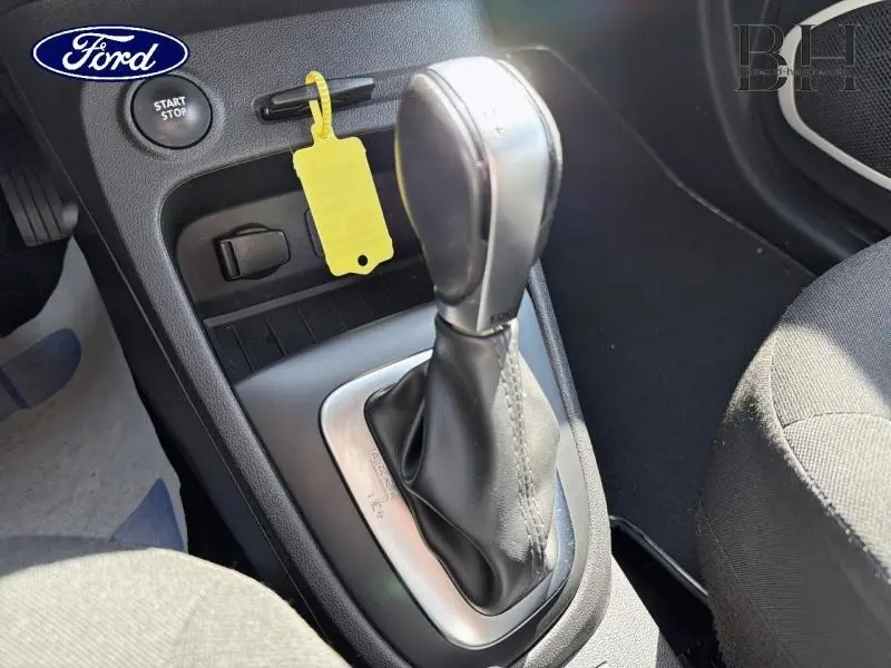 Gros plan sur la commande de boîte automatique noire et argentée dans l'habitacle d'un Renault Captur gris.