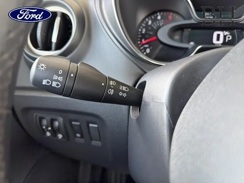 Gros plan sur la manette de commandes d'éclairage côté gauche du tableau de bord gris du Renault Captur gris Platine.