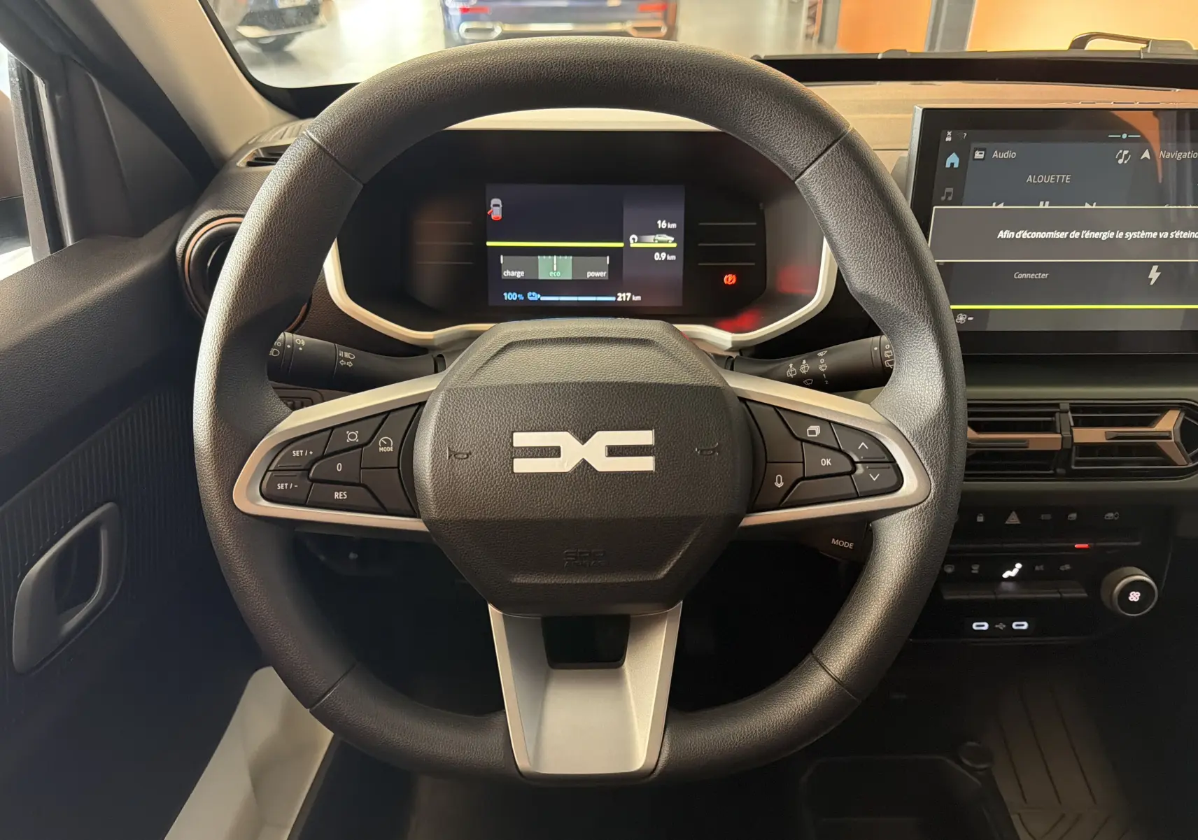 Vue centrée sur le volant du Dacia Spring 65 Extreme 2026, avec tableau de bord numérique et écran tactile.