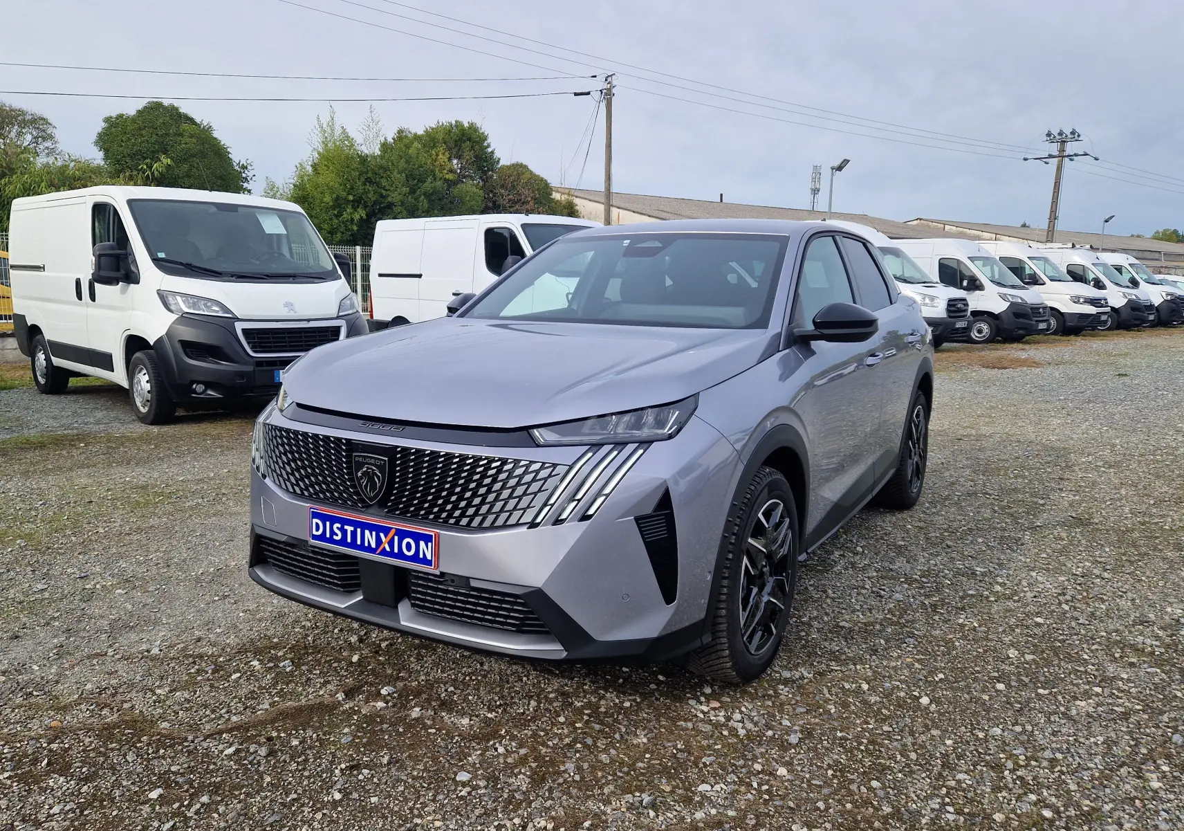 Peugeot 3008 gris Artense en 3/4 avant droit, avec calandre distinctive et jantes noires sur parking extérieur.