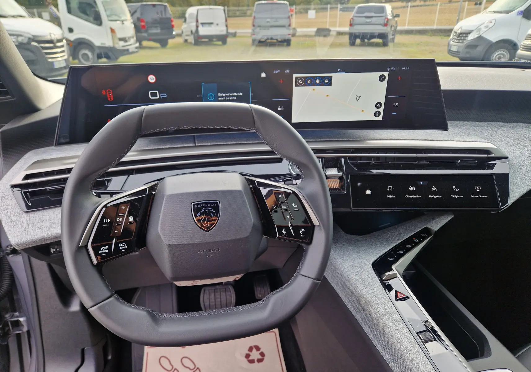 Vue intérieure du poste de conduite du Peugeot 3008 gris Artense 2025, avec volant cuir et écran panoramique tactile de 21 pouces.