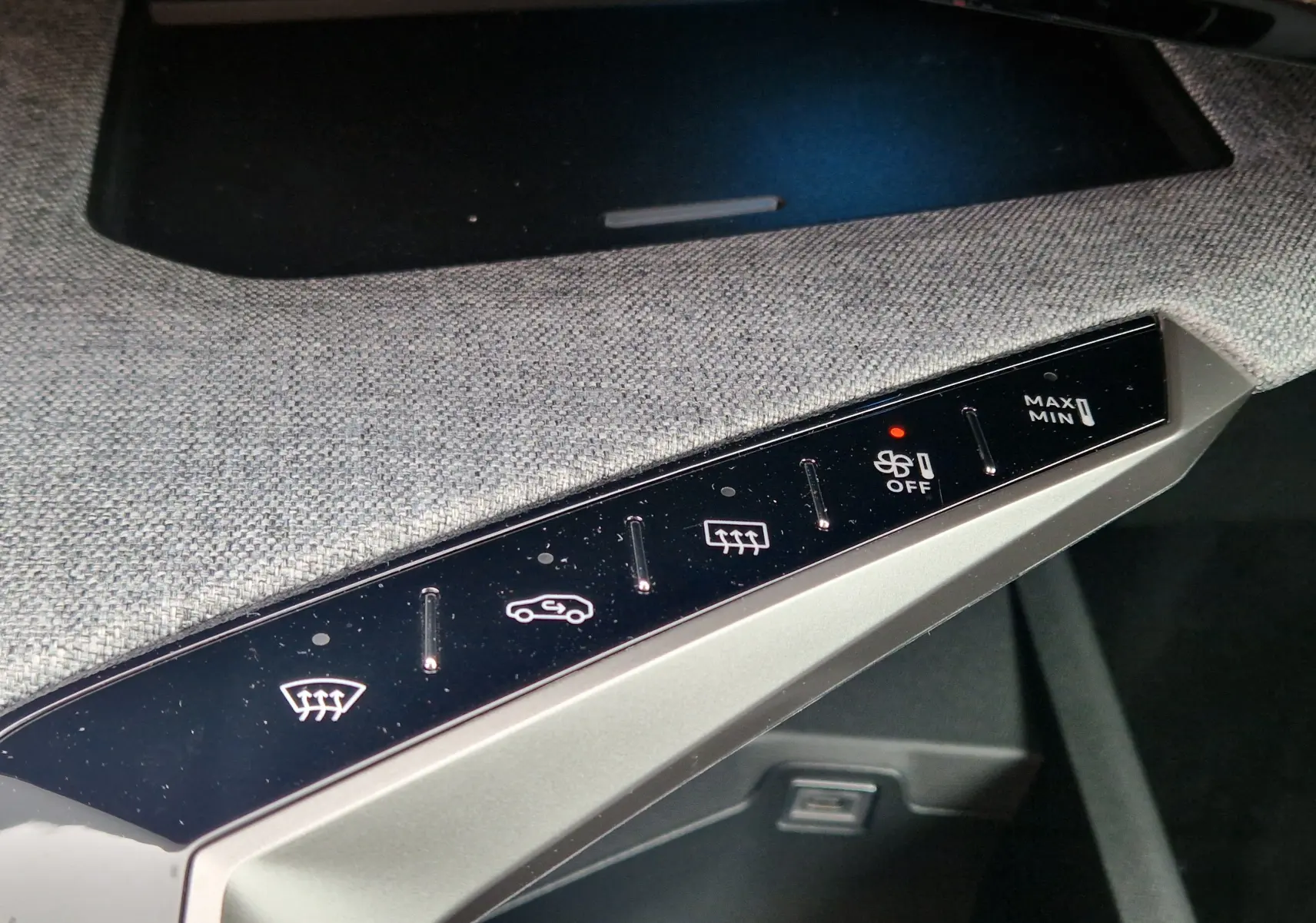 Gros plan sur les commandes de climatisation avec finition tissu gris dans l’habitacle du Peugeot 3008 gris Artense 2025.