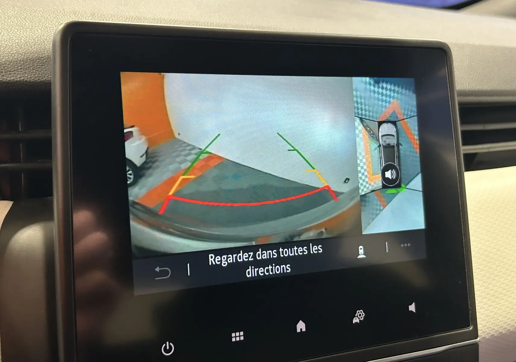 Écran multimédia montrant la caméra 360° en marche d'une Renault Clio V gris, vue arrière avec guidage de recul.