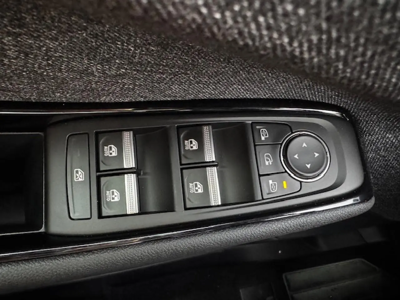 Gros plan sur les commandes de lève-vitres et rétroviseurs côté conducteur du Renault Espace VI noir étoilé.