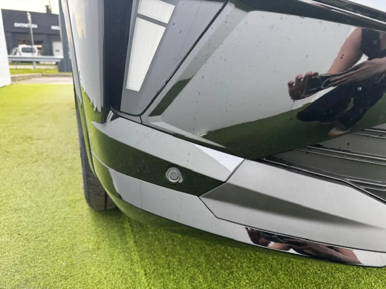 Gros plan sur le pare-chocs avant noir étoilé du Renault Espace VI avec capteur de stationnement intégré.