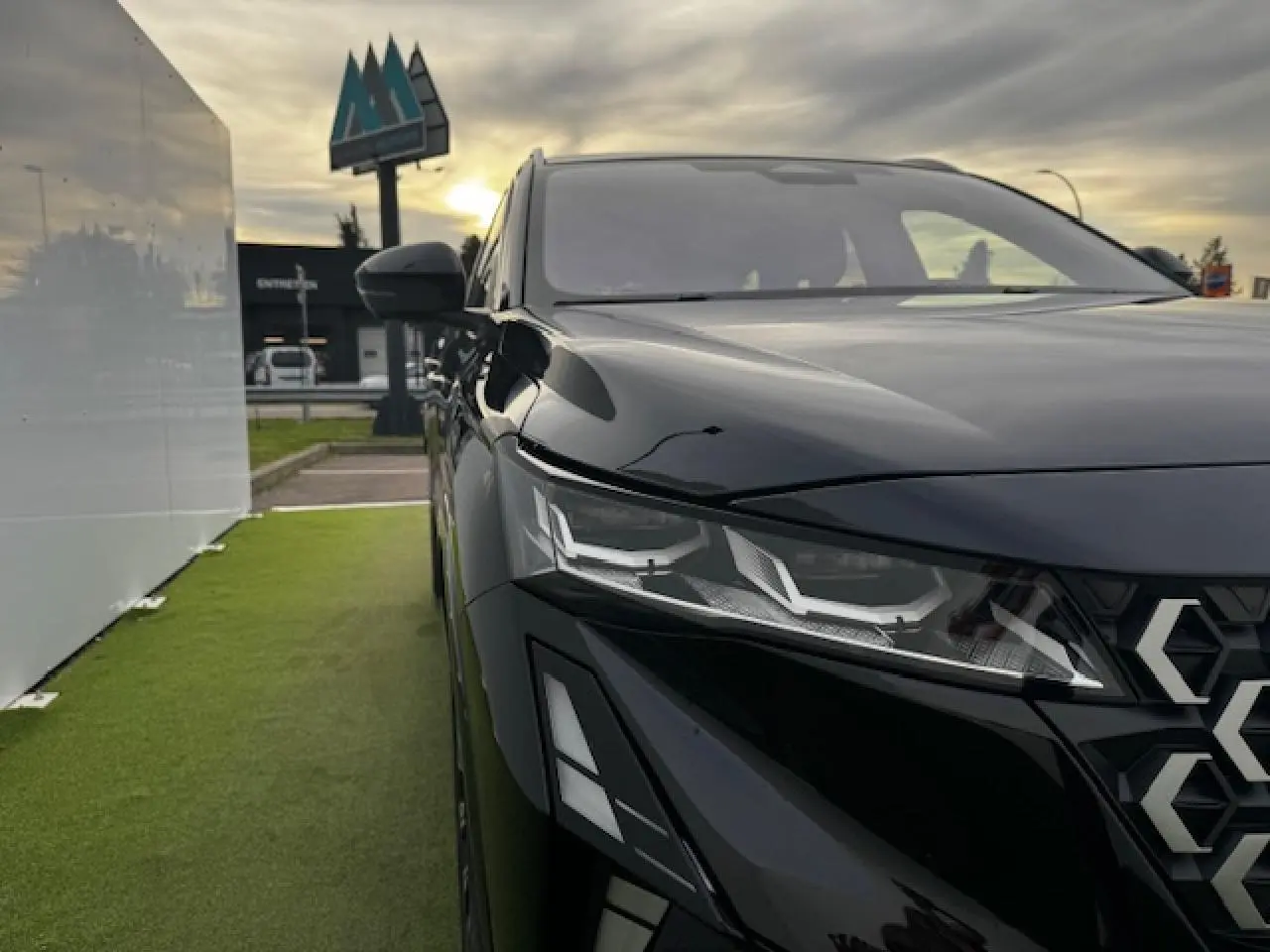 Gros plan sur l'avant droit du Renault Espace noir étoilé, mettant en valeur ses phares LED et la calandre gris chrome satin.