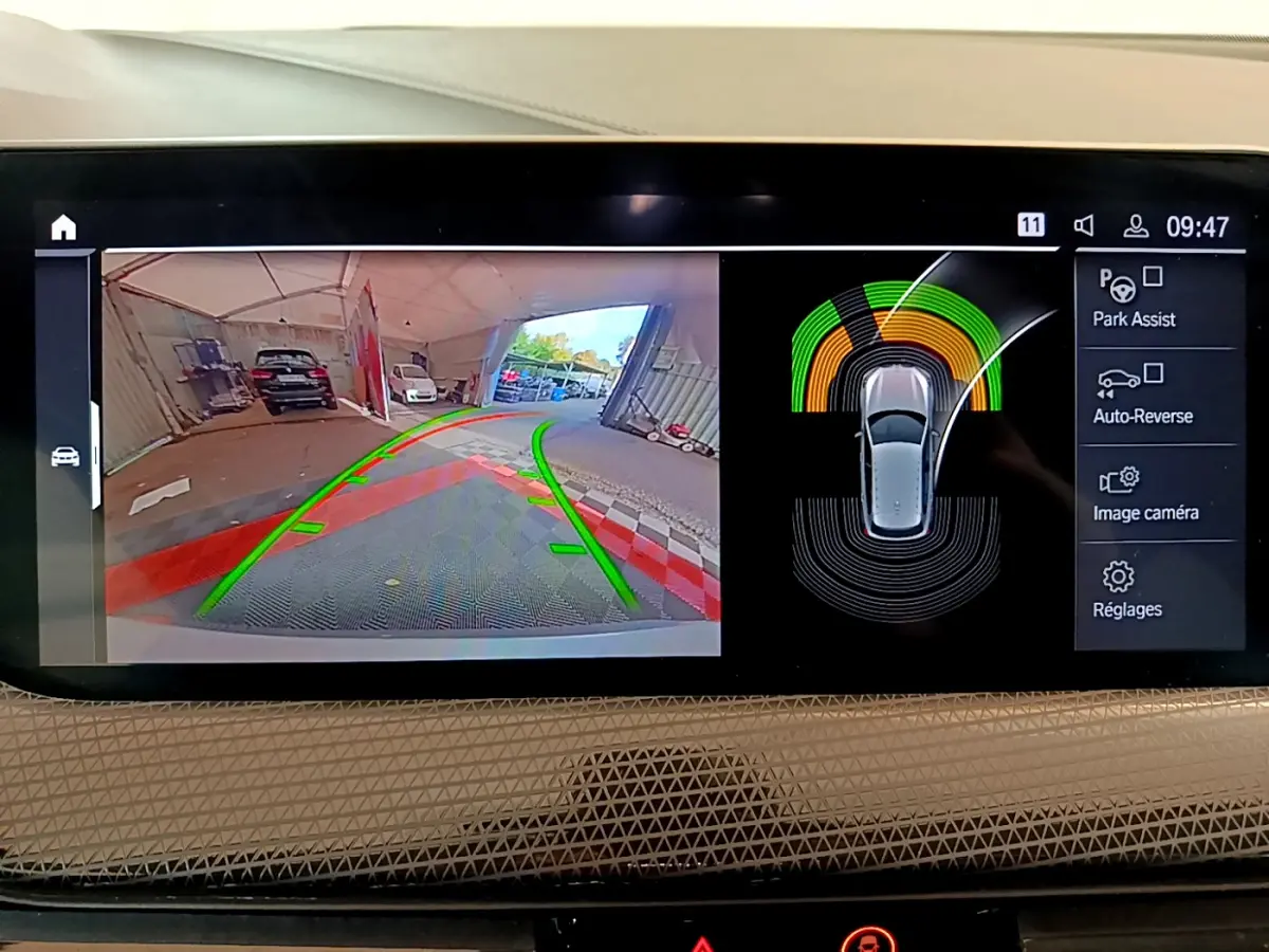 Écran multimédia de BMW Série 1 gris clair montrant la caméra de recul et l'aide au stationnement en intérieur.