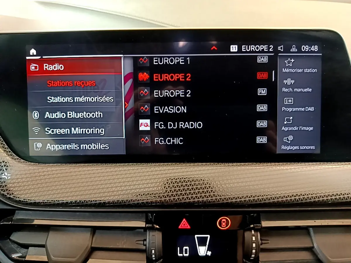 Écran central multimédia de BMW Série 1 118i 2021 affichant les stations radio et options connectées.